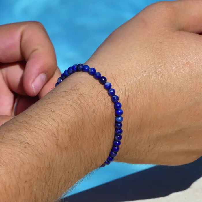 jeune homme portant un bracelet lapis lazuli au bord d'une piscine