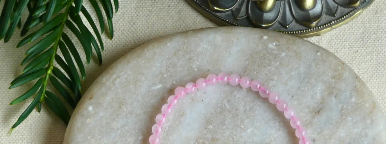 bracelet quartz rose en gros plan, posé sur une pierre plate