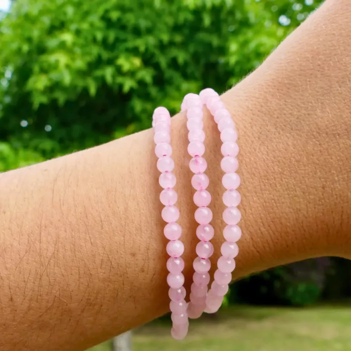 un bracelet en quartz rose au poignet d'une jeune femme