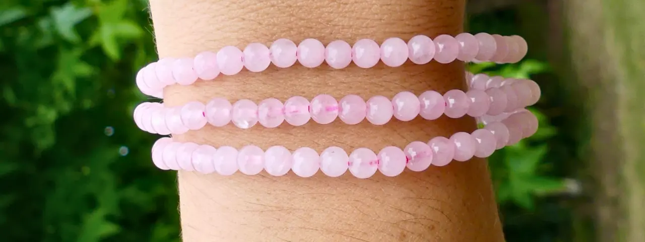 un bracelet en quartz rose au poignet d'une jeune femme en gros plan