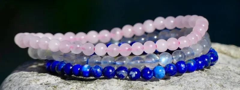 Trois bracelets en pierre naturelle posés sur un rocher