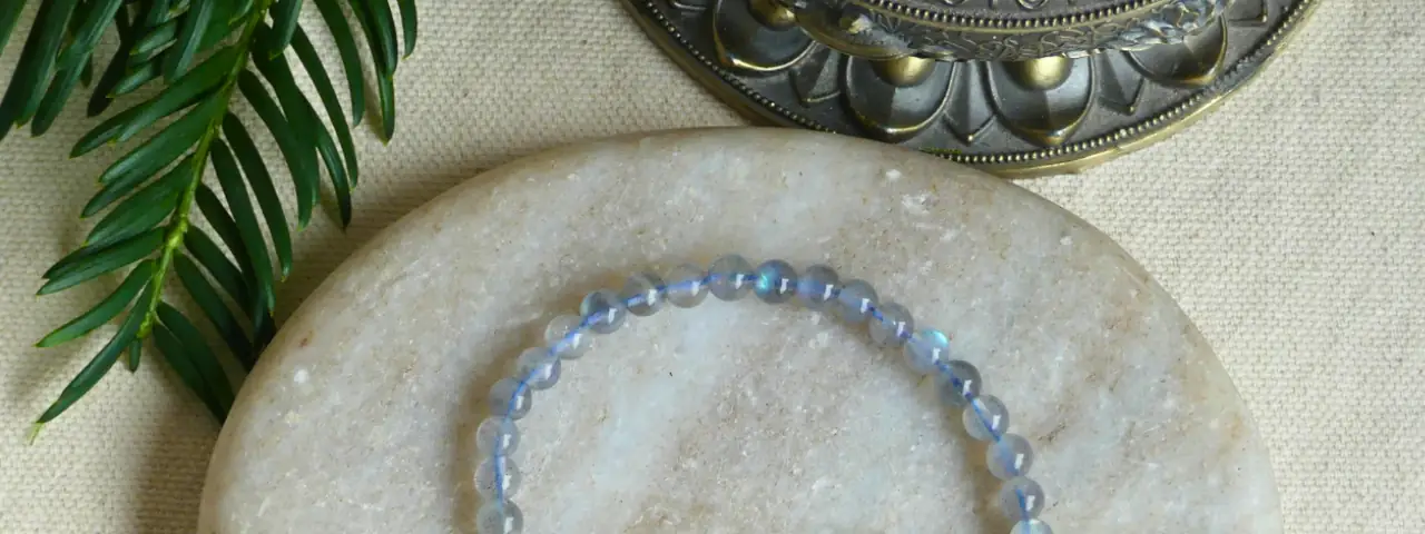 un bracelet labradorite posé sur une pierre plate