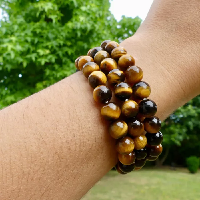 trois bracelets oeil de tigre sur le poignée d'une jeune femme