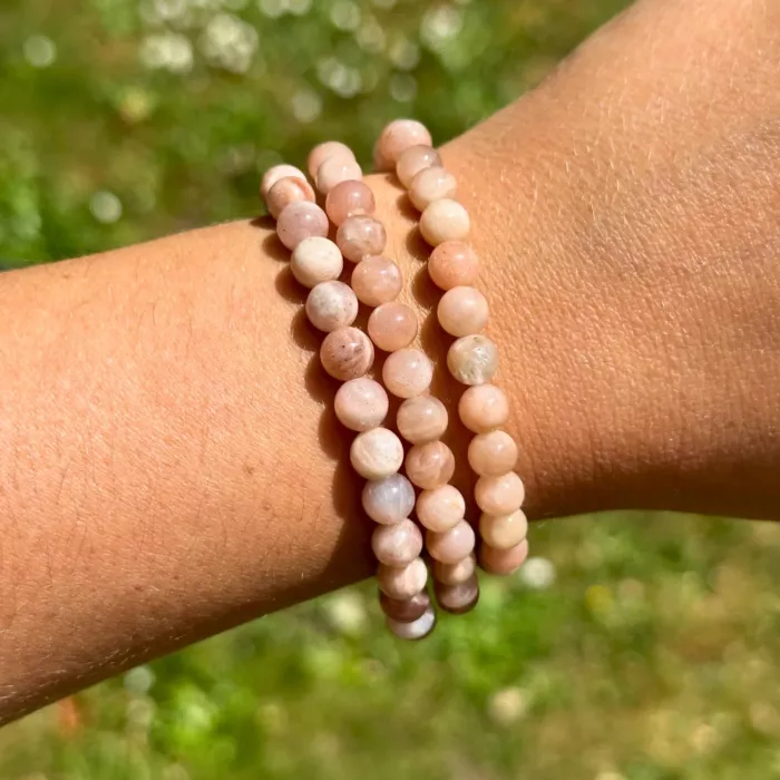 Jeune femme ayant trois bracelets pierre de soleil 6 mm