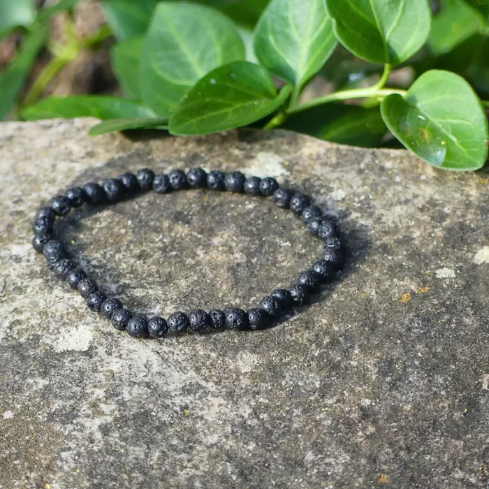 Un bracelet en pierre de soleil posé sur un rocher, mi ombre