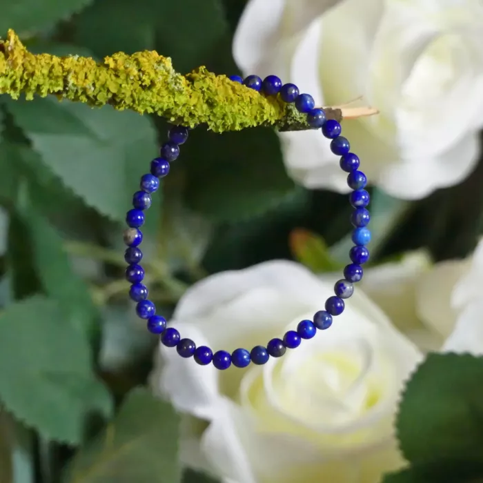 Bracelet lapis lazuli en gros plan, posé sur une branche