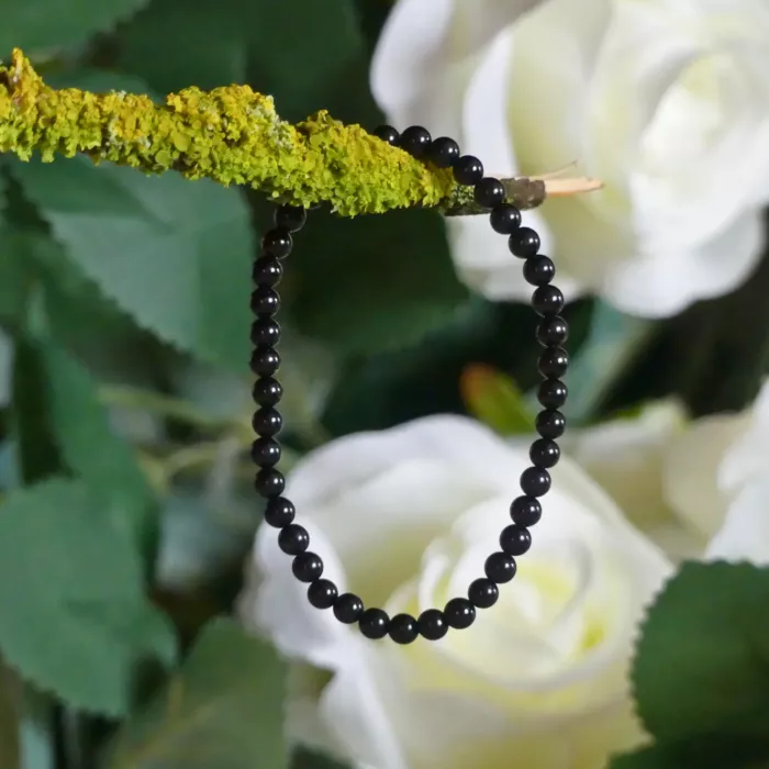 Bracelet tourmaline en gros plan, posé sur une branche