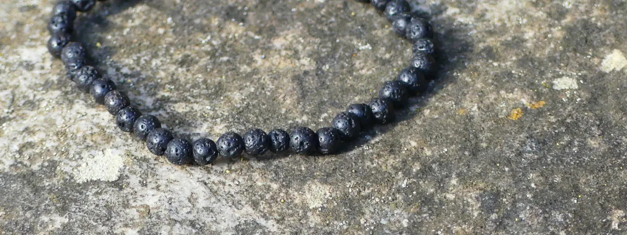 bracelet pierre de lave posé sur un rocher