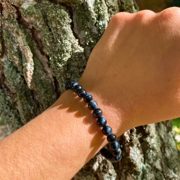 Un bracelet oeil de faucon au poignet d'une jeune femme