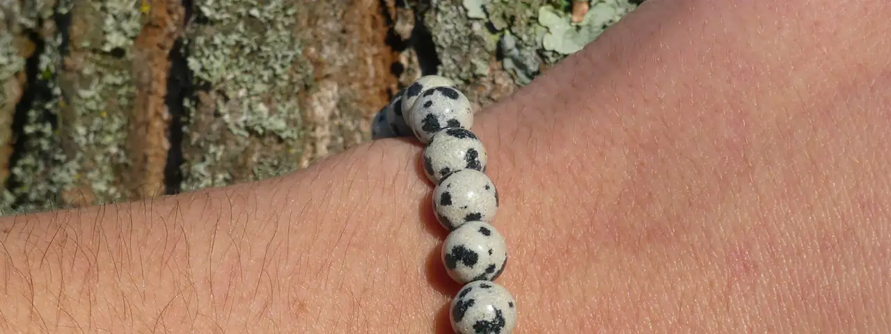 bracelet jaspe dalmatien au poignet d'une jeune femme en gros plan