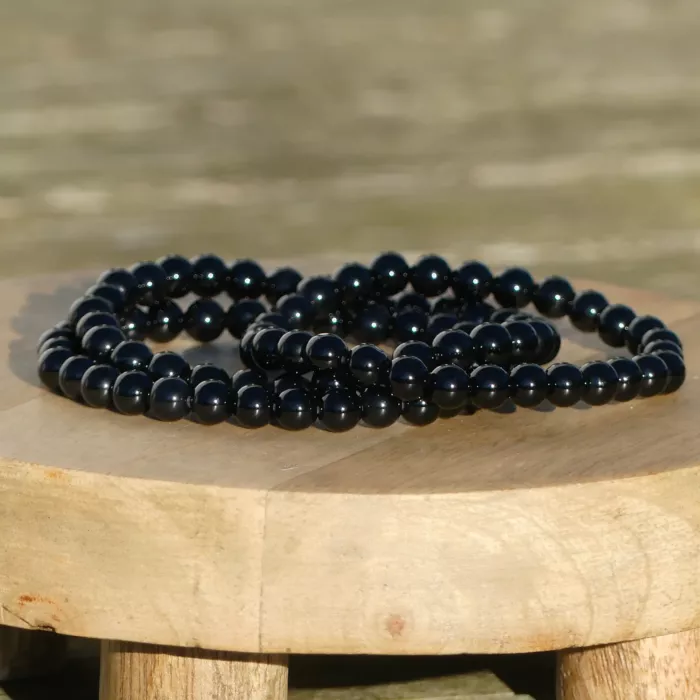 trois bracelets onyx posés sur une planche