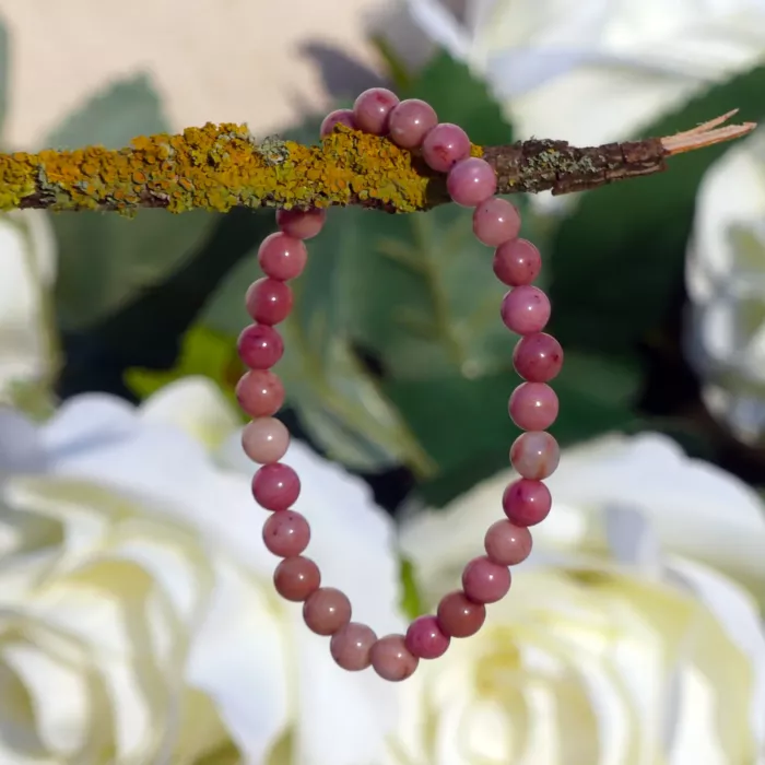 bracelet rhodonite posé sur une branche