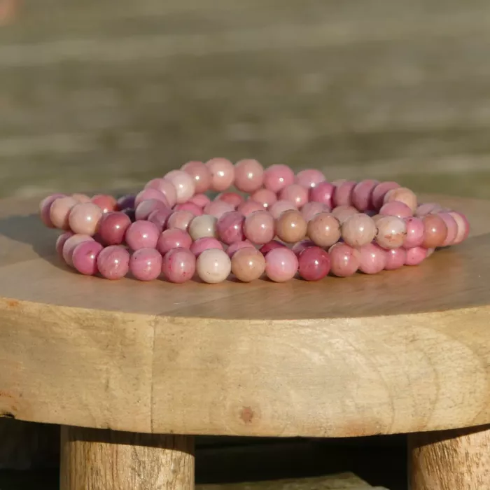 bracelet rhodonite sur une planche, dans un jardin