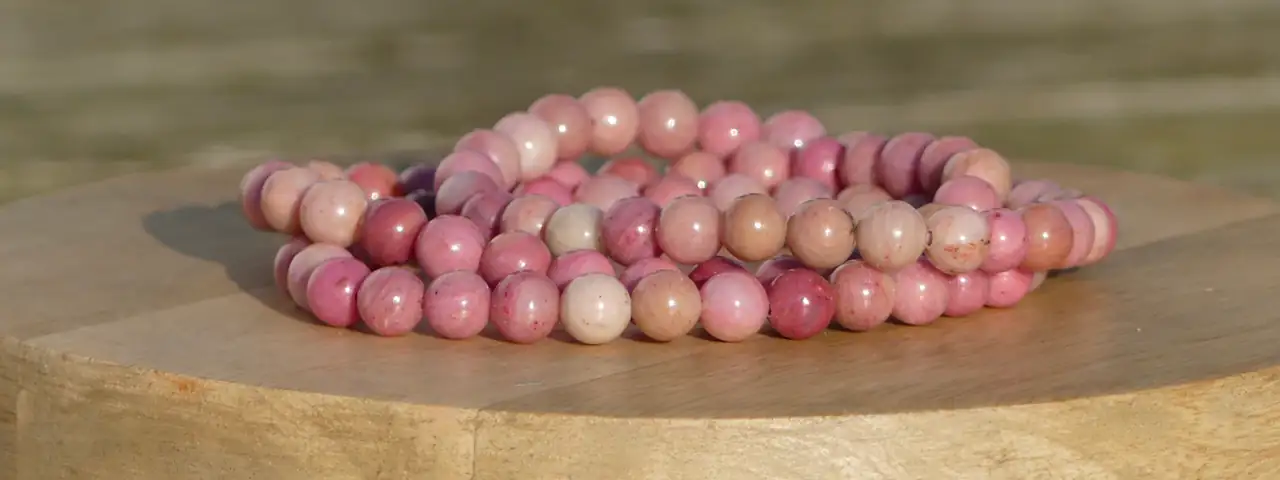 bracelet rhodonite sur une planche, dans un jardin