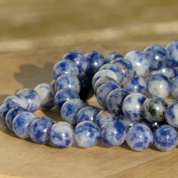 bracelet sodalite posé sur une planche dans un jardin en gros plan