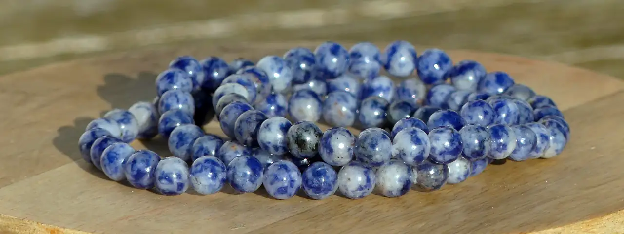 bracelet sodalite posé sur une planche dans un jardin