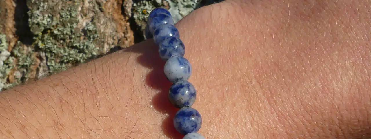 bracelet sodalite porté au poignet par une jeune femme en gros plan