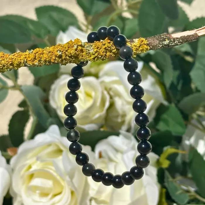 bracelet obsidienne dorée sur une branche