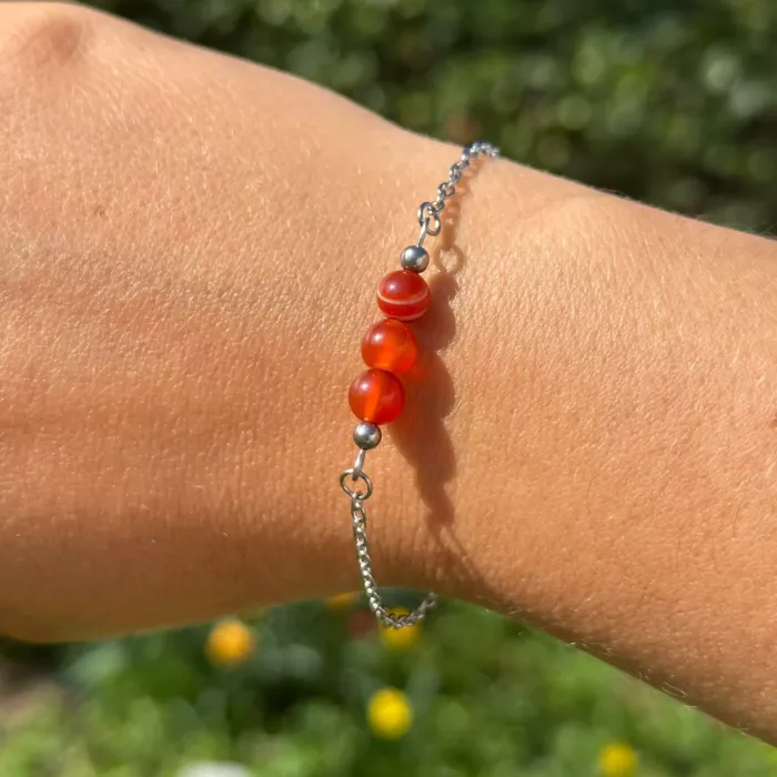bracelet Reliques n°2 monté avec des perles cornalines, sur le poignet d'une jeune femme