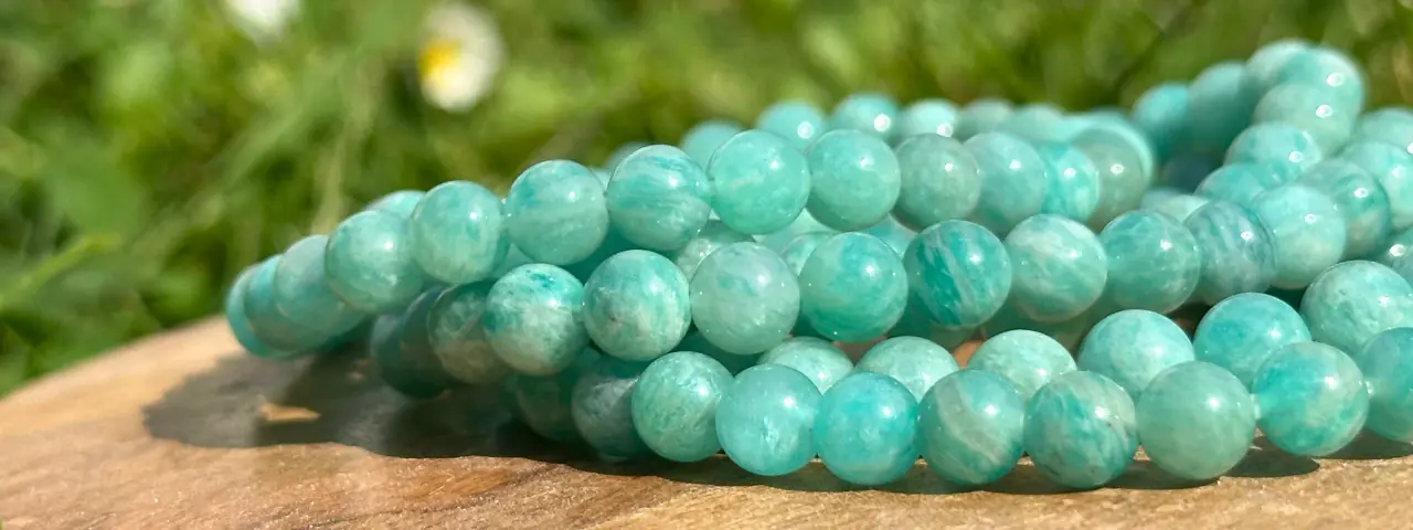 Bracelet amazonite de différentes tailles posés sur un socle en bois en gros plan