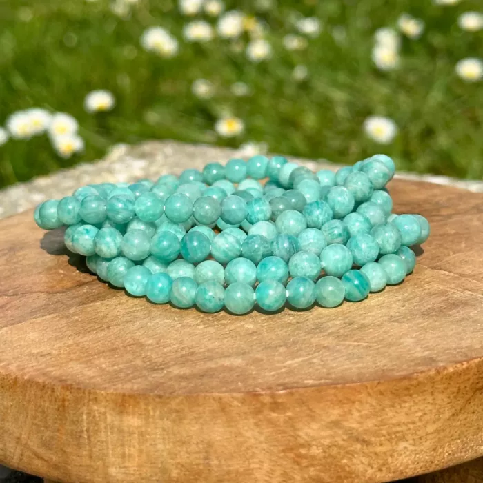 Bracelet amazonite de différentes tailles posés sur un socle en bois