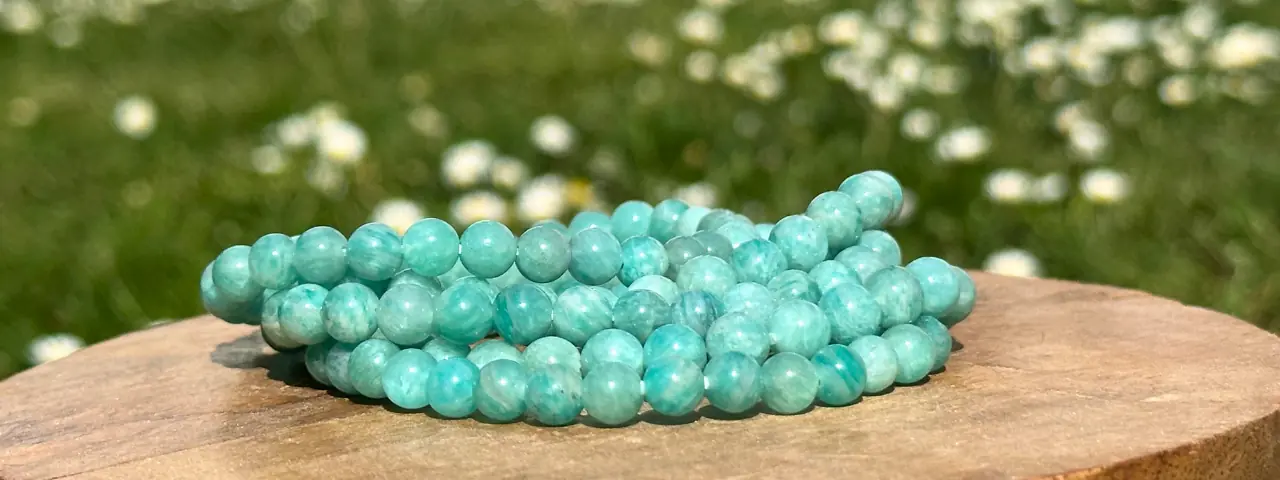 Bracelet amazonite de différentes tailles posés sur un socle en bois en gros plan