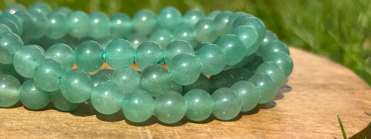 Bracelet aventurine verte 6 mm en gros plan sur une planche en bois