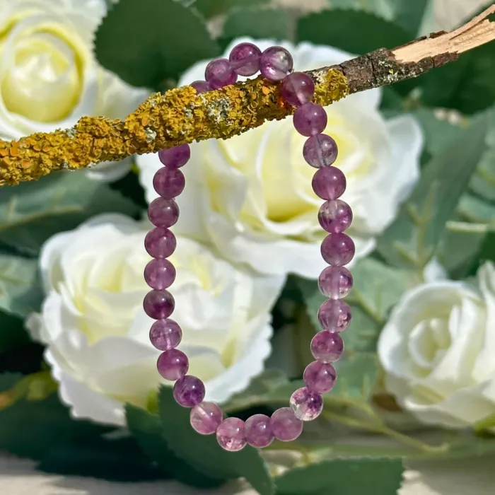 Bracelet fluorite violette posé sur une branche