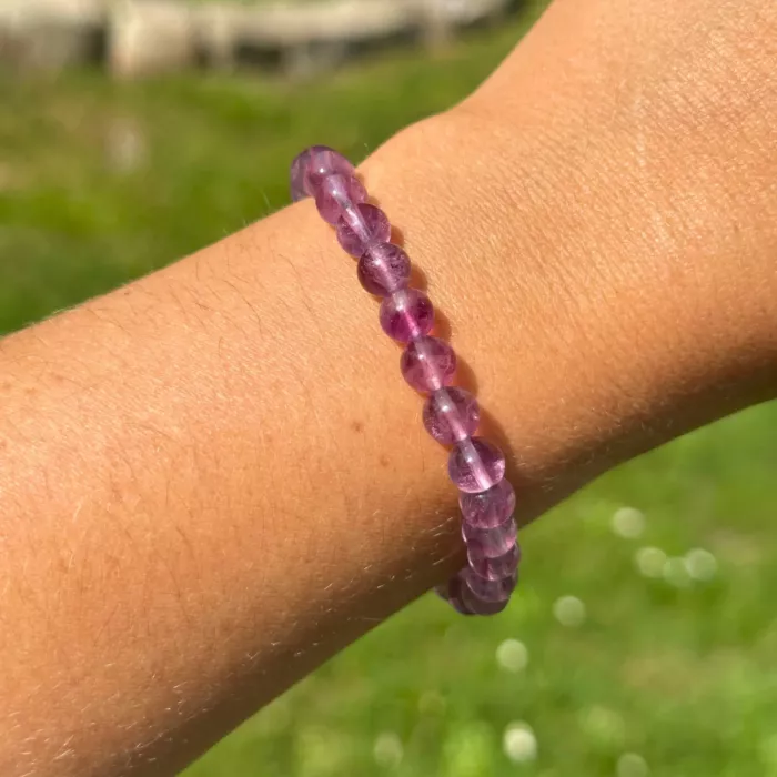 Bracelet fluorite violette au poignet d'une jeune femme