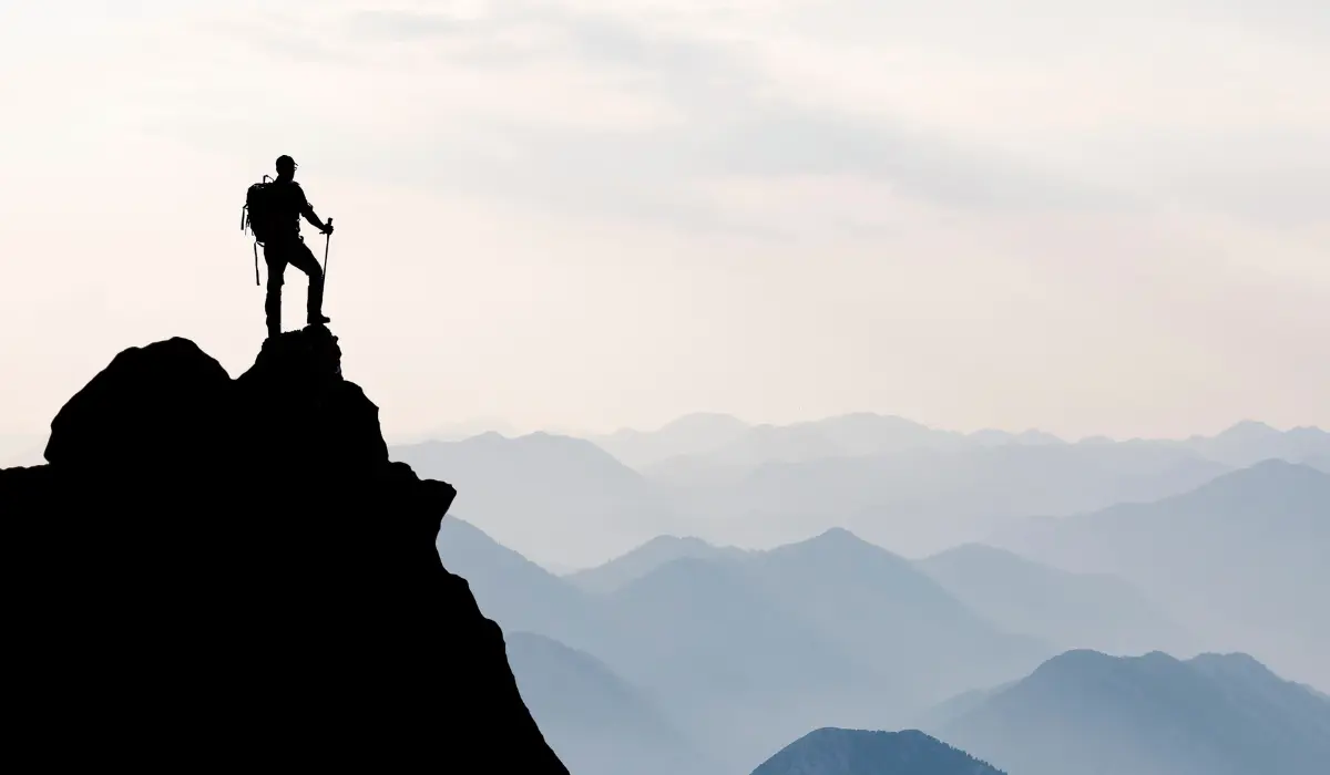 Homme en haut d'une montagne, illustrant la persévérance de 444