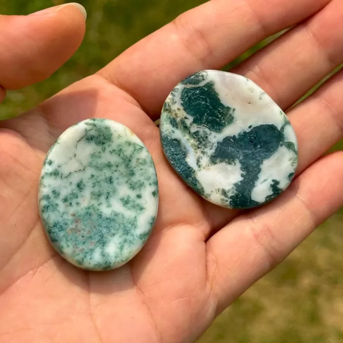 Galet anti-stress en agate arbre tenu dans la main d'une jeune femme