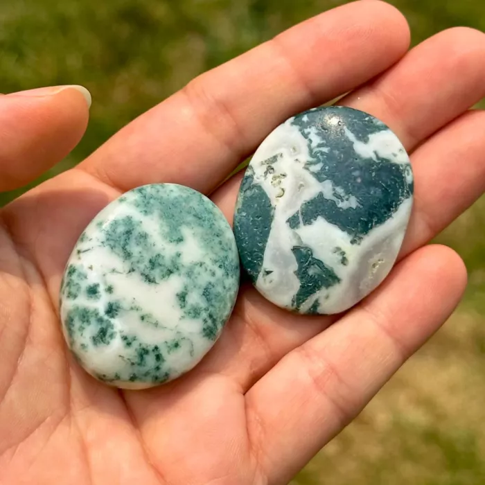 Galet anti-stress en agate arbre tenu dans la main d'une jeune femme