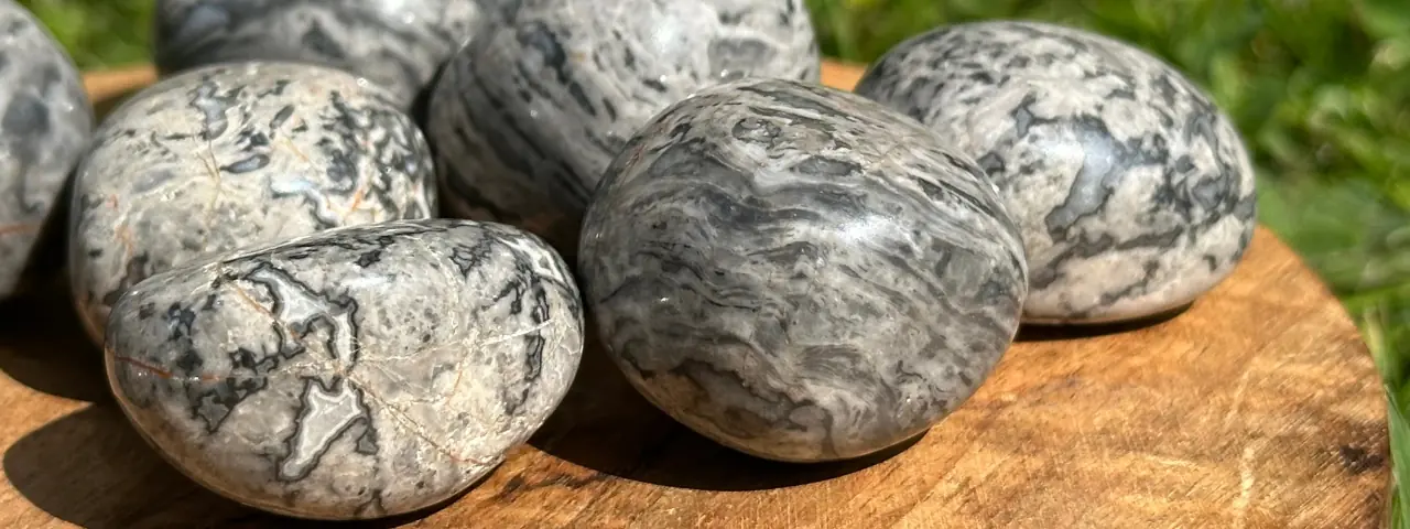 Agate crazy lace grise roulée posé sur un plateau en bois