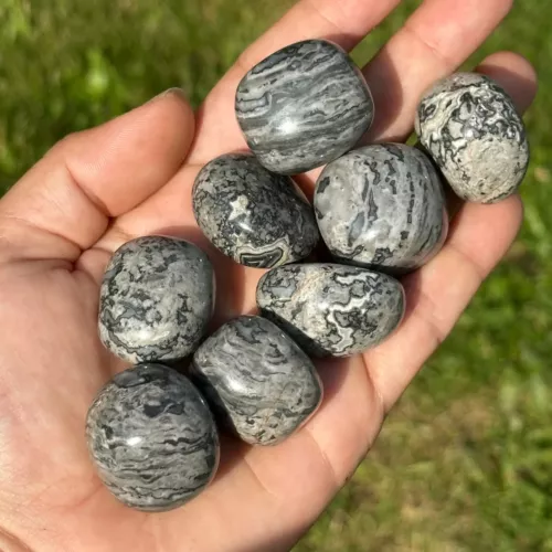 Agate crazy lace grise roulée dans la main d'une jeune femme