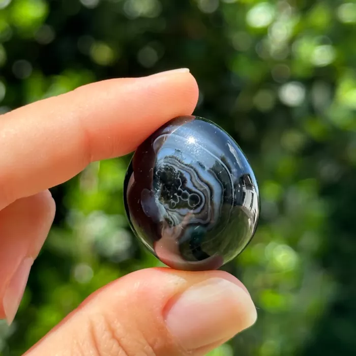 Agate oeil roulée entre les doigts d'une jeune femme