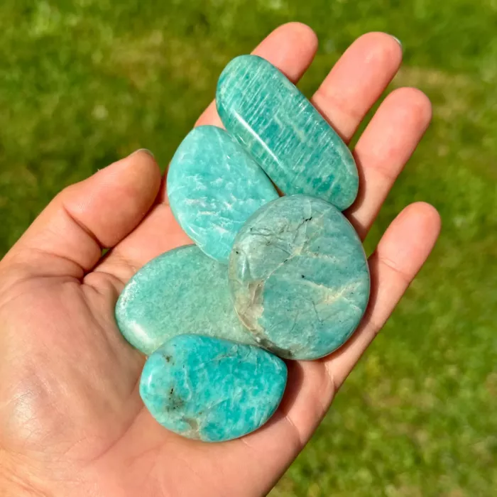 Plusieurs pierres amazonite tenues dans la main