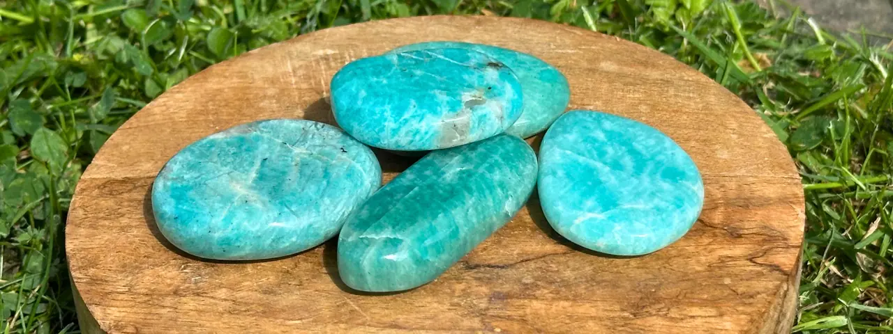 Plusieurs pierres d'amazonite posées sur un bloc de bois