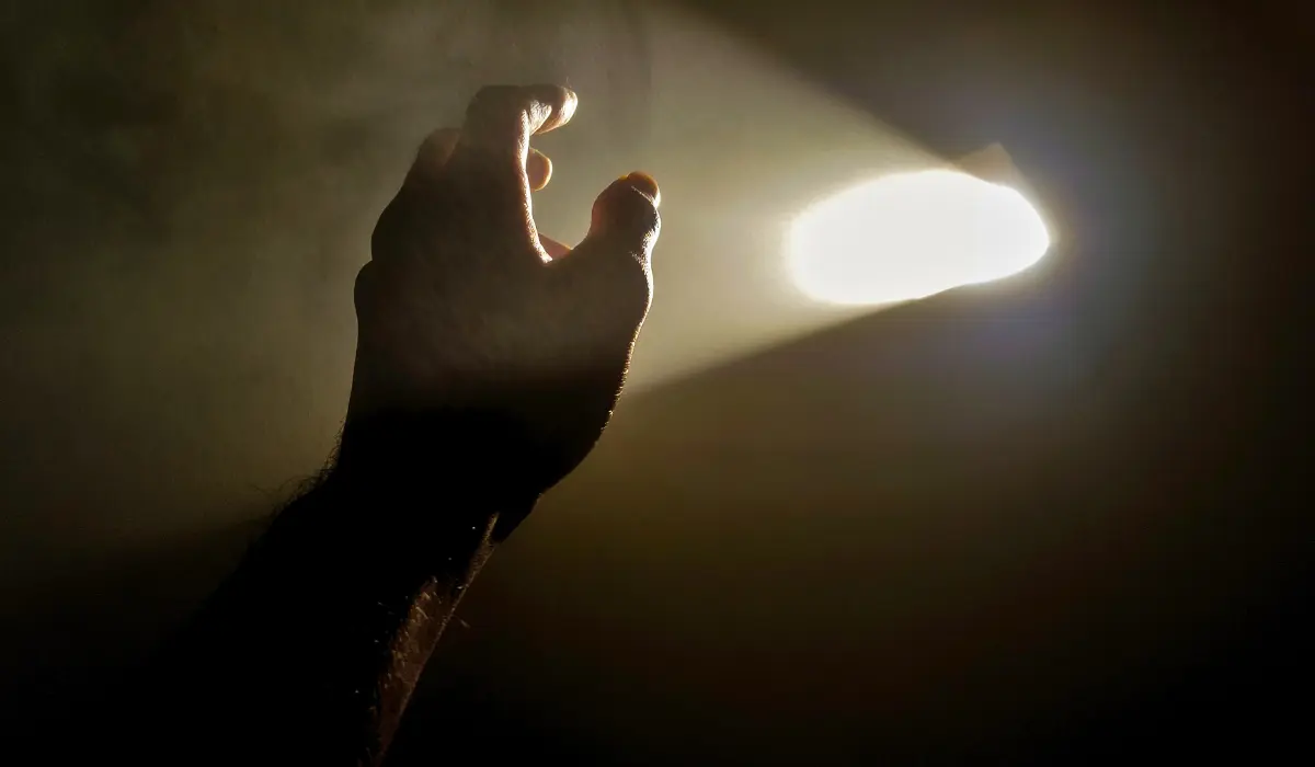 Main au devant d'une lumière représentant l'âme humaine