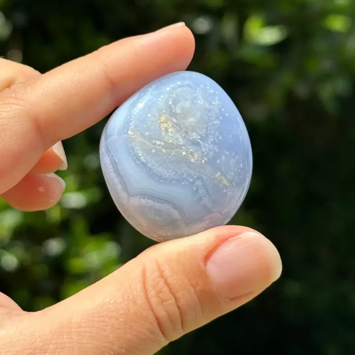 Calcédoine bleue roulée entre les doigts