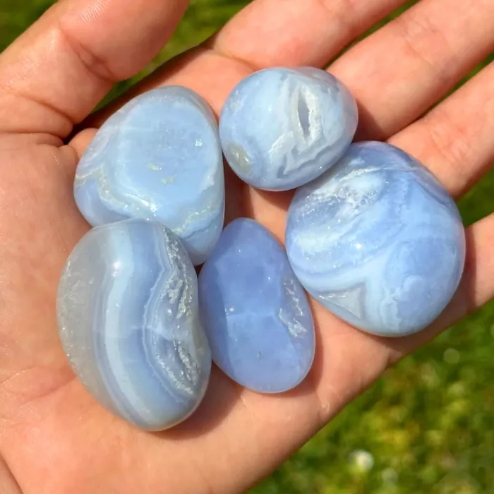 Calcédoine bleue roulée dans une main