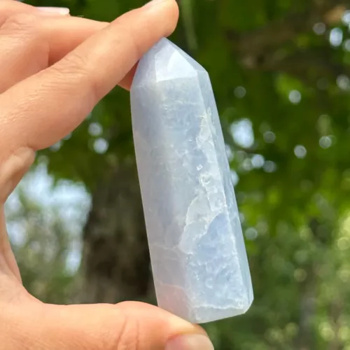 Calcite bleue pointe polie entre les doigts