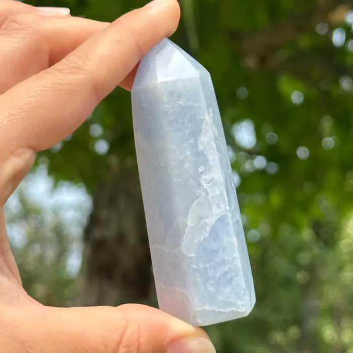 Calcite bleue pointe polie entre les doigts