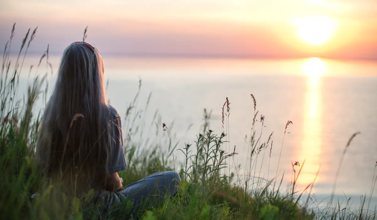 Jeune femme scrutant l'horizon, illustrant la pensée lors d'un changement de vie
