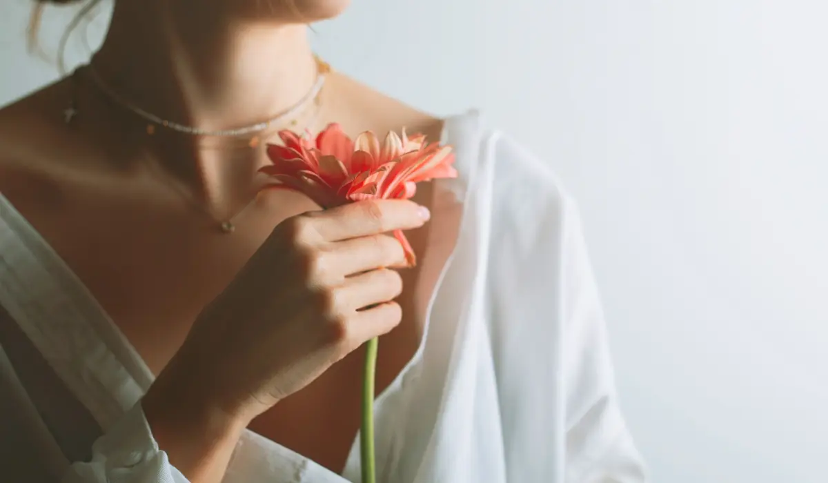 Jeune femme tenant une fleur pour illustrer la conscience