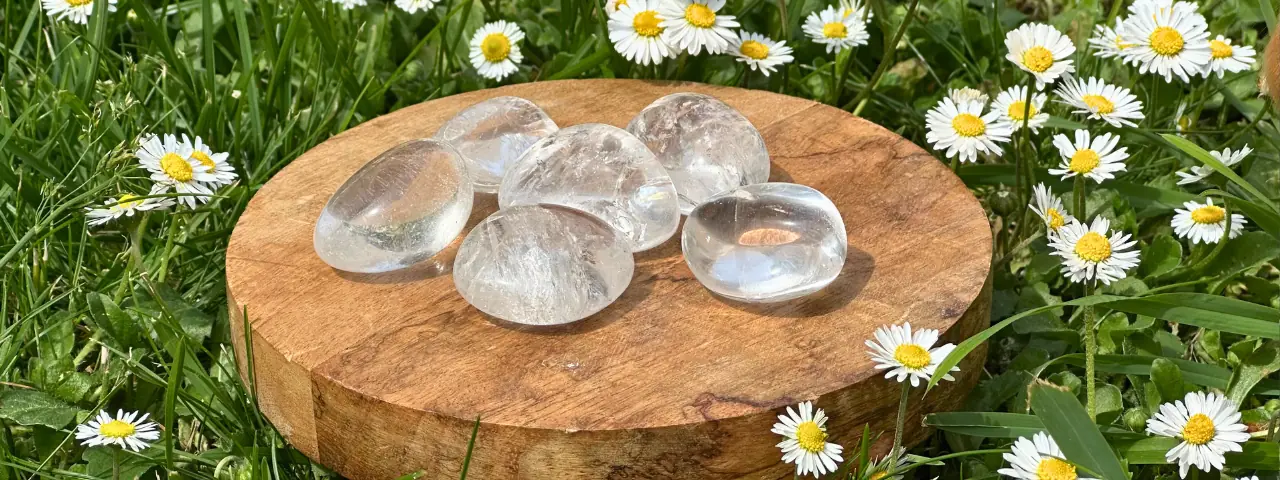 Du cristal de roche roulé posé sur une planche de bois