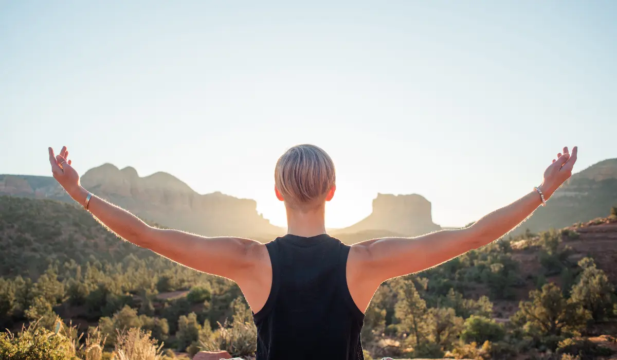 Jeune femme ouvrant les bras sur la nature pour laisser passer les pensées