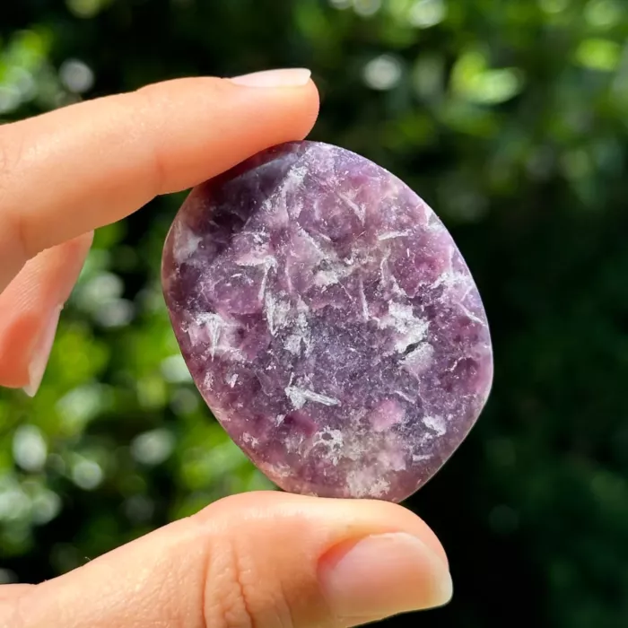 Lépidolite entre les doigts