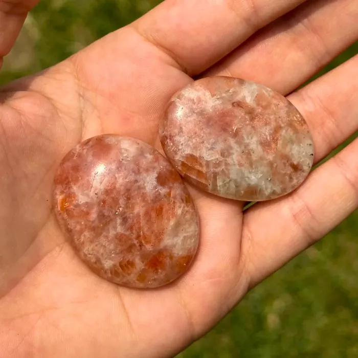 Galet anti-stress en pierre de soleil tenu dans la main