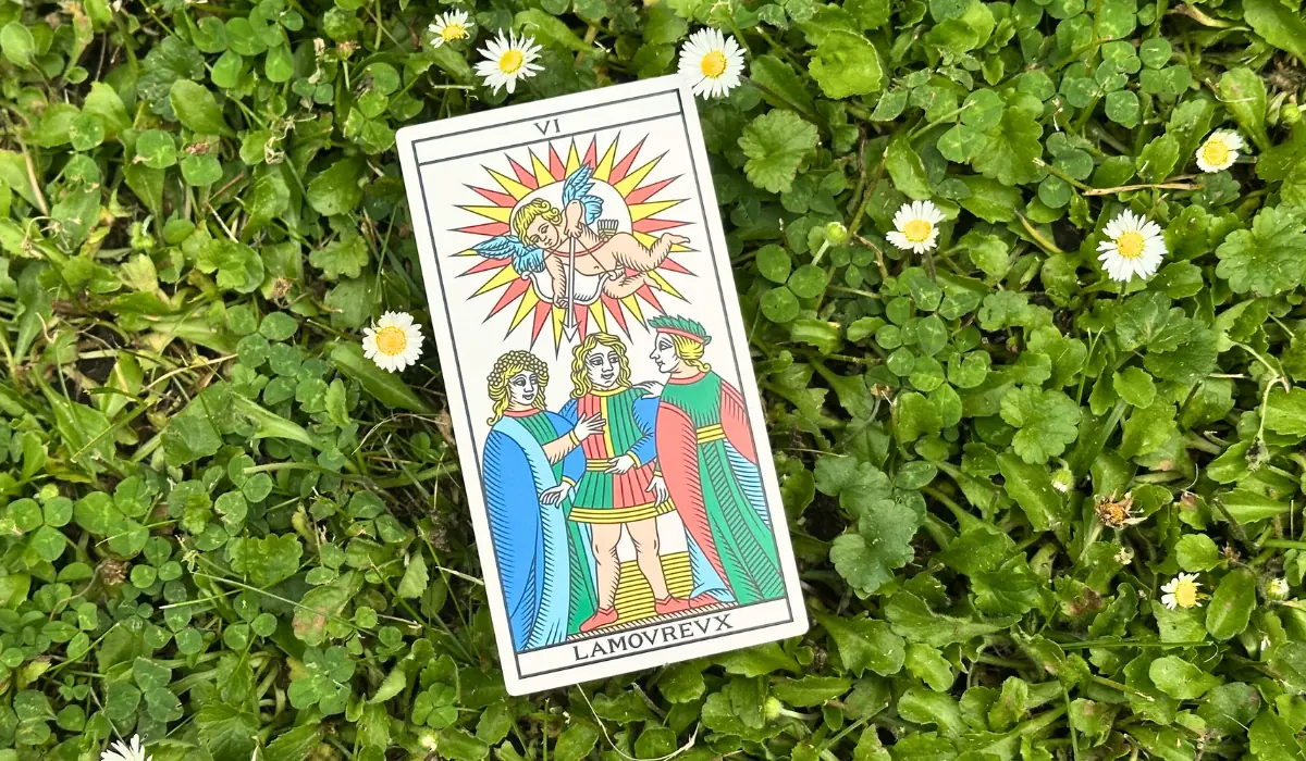 L'arcane de l'Amoureux du Tarot de Marseille, posé dans l'herbe