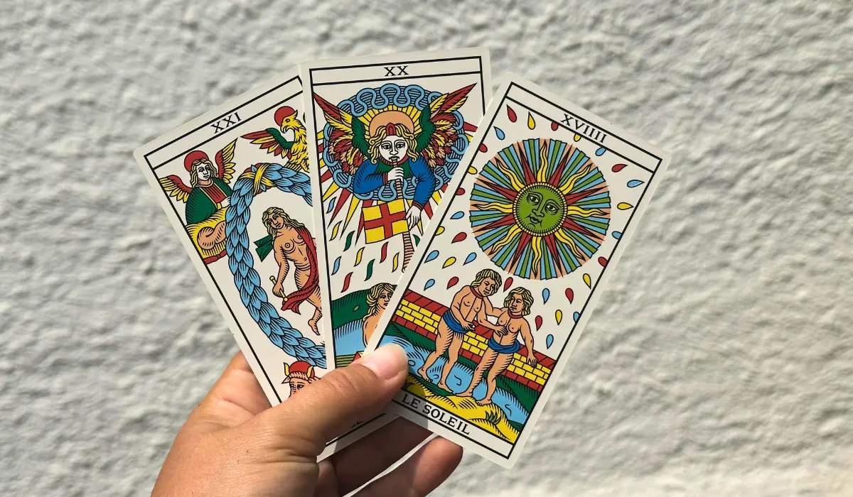 Arcanes du tarot de Marseille tenu dans la main d'une jeune femme